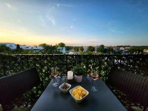 stół z kieliszkami do wina i jedzeniem na balkonie w obiekcie L'arène du Stade de France - 100 mètres + parking w mieście Saint-Denis