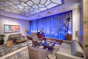 a large living room with blue curtains and couches at Grandeur Hotel Al Barsha in Dubai