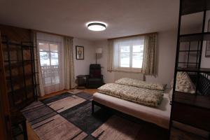 a bedroom with a bed and two windows at 4 Barga Blick in Partenen