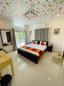 Krishna kottage A Boutique Home Stay في أودايبور: غرفة نوم بسرير وسقف زهرة