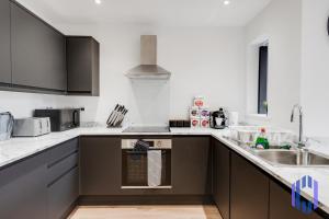 a kitchen with a sink and a stove top oven at Stylish 4bd - Hot tub - Etihad - Games -Parking-EV in Manchester