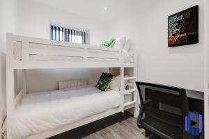 sypialnia z 2 łóżkami piętrowymi i telewizorem w obiekcie Stylish 4bd - Coop LIVE - Etihad - Parking - EV w Manchesterze