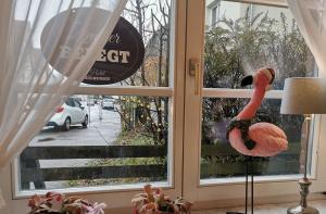 ein Flamingo steht vor einem Fenster in der Unterkunft Hotel Deichvoigt in Cuxhaven