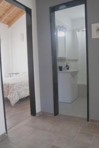 a room with a mirror and a sink and a bed at Casa de Playa in Puerto Madryn