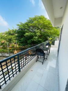 a balcony with two chairs and a table at Krishna kottage A Boutique Home Stay in Udaipur