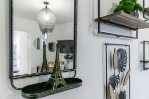 einen Spiegel mit dem Eiffelturm auf einem Regal in der Unterkunft MBA Splendide Appart Diderot 2 - Proche Vincennes in Montreuil