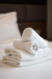 uma pilha de toalhas sentadas em cima de uma cama em Smartflats - Midi 33 em Bruxelas