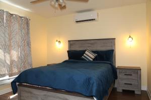 um quarto com uma cama com um edredão azul em Suriz Cottage em Lansdowne