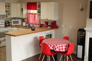 uma cozinha com uma mesa e cadeiras em xadrez vermelha e branca em Suriz Cottage em Lansdowne