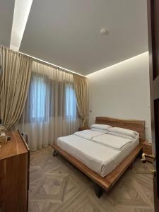 フィレンツェにあるホテル ル ドゥエ フォンターヌのベッドルーム(白いシーツを使用した大型ベッド1台付)