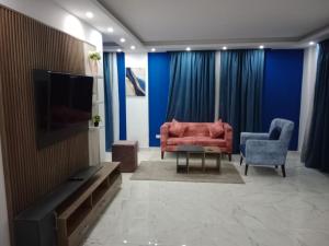 Fanadir Resort 306 Albatross في الغردقة: غرفة معيشة مع أريكة حمراء وكرسيين زرقاء