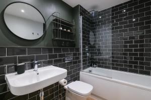a bathroom with a sink and a toilet and a mirror at Apartments in Cardiff in Cardiff