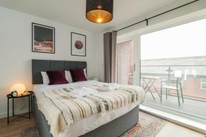 a bedroom with a bed and a large window at Apartments in Cardiff in Cardiff