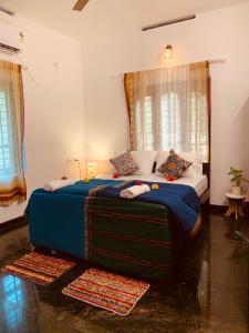 sypialnia z dużym łóżkiem i niebieskim kocem w obiekcie Villa Mandala Guest House w mieście Varkala
