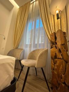 2 sillas frente a una ventana en una habitación de hotel en Hotel Le Due Fontane, en Florencia