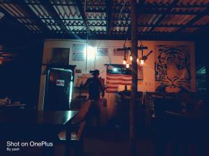 戈卡尔纳Surya cafe and stay sea view的站在带冰箱的厨房中的男人