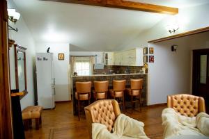 una cucina con bancone e sedie in camera di Casa Lulu a Dorna Cîndrenilor