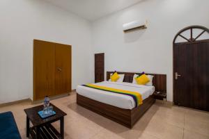 a bedroom with a large bed and a table at Itsy By Treebo - Om Pushp Residency in Mathura