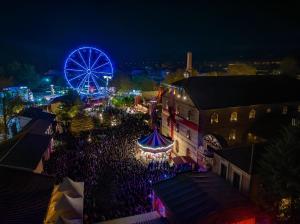 an aerial view of a carnival at night with a ferris wheel at Εlite Αpartment Trikala in Tríkala