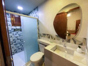 a bathroom with a toilet and a mirror at Pousada Monte Flor Guaramiranga CE in Guaramiranga