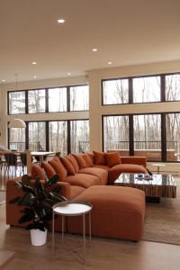 a living room with a brown couch and a table at Le Singapour - Cottage Resort - Brownsburg-Chatham in Brownsburg