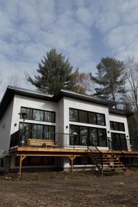 a house with a large window and a deck at Le Singapour - Cottage Resort - Brownsburg-Chatham in Brownsburg