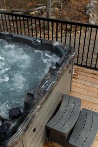 a hot tub on a deck with a bench at Le Singapour - Cottage Resort - Brownsburg-Chatham in Brownsburg