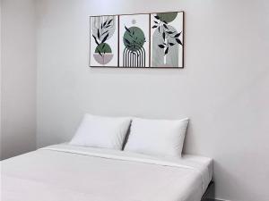 Un dormitorio con una cama blanca y una foto en la pared en Haha House en Ho Chi Minh
