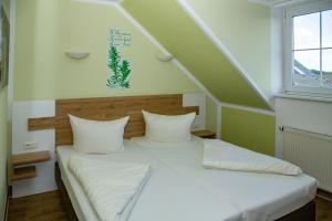 Schlafzimmer mit einem Bett mit weißer Bettwäsche und einem Fenster in der Unterkunft Hotel Zum Stern Spreewald in Werben