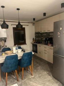 a kitchen with a table and chairs and a refrigerator at Apartament UltraLux cu 3 camere in Craiova