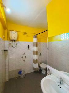 a bathroom with a sink and a shower and a toilet at Angels River Villa in Canacona