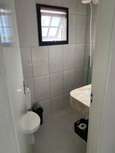 een badkamer met een toilet, een wastafel en een raam bij Casa do Hia em Ubatuba - Lagoinha in Ubatuba