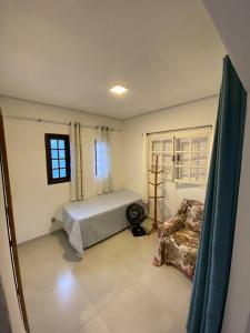 een slaapkamer met een bed en een raam bij Casa do Hia em Ubatuba - Lagoinha in Ubatuba