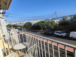 un balcón con vistas a una calle con coches en Waterside, en Birżebbuġa