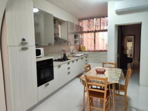 una cucina con un tavolo e un tavolo e sedie di Waterside a Birżebbuġa