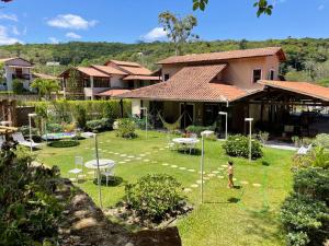 uma criança a brincar num quintal em frente a uma casa em Pousada Monte Flor Guaramiranga CE em Guaramiranga