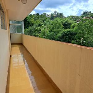 um quarto com uma varanda com vista para as árvores em Apartamento Aconchegante Centro Serra Negra em Serra Negra