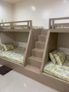 two bunk beds in a room with stairs at PMPJ Cabin in Lipa