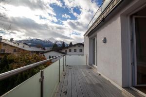 Il dispose d'un balcon avec une terrasse en bois et des montagnes en arrière-plan. dans l'établissement Pine Residence Zell am See - Steinbock Lodges, à Zell am See