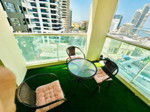 Habitación con 3 sillas y balcón con mesa. en Deluxe GIRLS HOSTEL en Dubái