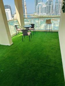 a balcony with green grass and a table and chairs at Deluxe GIRLS HOSTEL in Dubai