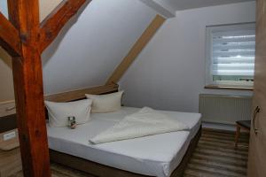 a small bedroom with a bed with a wooden post at Hotel Zum Stern Spreewald in Werben