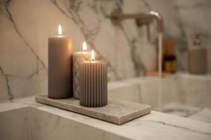 two candles sitting on a counter in a bathroom at Giotto Suite With View in Florence