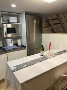 a kitchen with a table with a bottle of wine at MADRID CENTRO II in Madrid