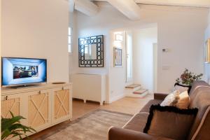 a living room with a couch and a television at Giotto Suite With View in Florence
