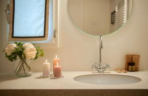 a bathroom sink with two candles and a mirror at Giotto Suite With View in Florence