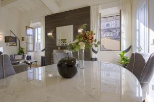 a dining room with a table with a vase of flowers at Giotto Suite With View in Florence