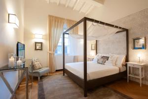a bedroom with a canopy bed and a chair at Giotto Suite With View in Florence