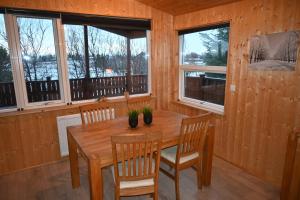 uma sala de jantar com uma mesa de madeira e cadeiras em Thingvellir Cabin/Chalet em Selfoss
