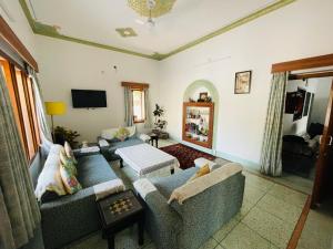 a living room with two couches and a tv at Krishna kottage A Boutique Home Stay in Udaipur